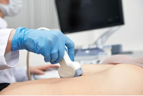 Doctor gives the patient a female abdominal ultrasound.