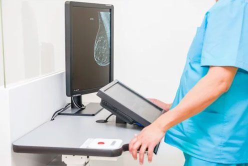 Doctor looking at mammogram snapshot of breasts of a female patient on the monitor.